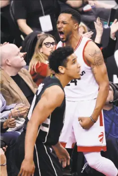  ?? Nathan Denette / Associated Press ?? Toronto guard Norm Powell (rear) reacts after drawing a foul while making a basket in front of Milwaukee’s Malcolm Brogdon.