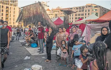  ?? DIEGO IBARRA SANCHEZ NEW YORK TIMES ?? People wait for food and aid distributi­on in Beirut on Thursday after an explosion two days earlier left thousands in need.
