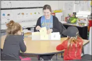  ?? (NWA Democrat-Gazette/Rachel Dickerson) ?? Elaine Frost (center), a first-grade teacher at Cooper Elementary School, quizzes two students on sounds that letters make during Launch Pad, a new after-school program designed to help students in literacy and math.