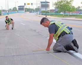  ?? MEG JONES / MILWAUKEE JOURNAL SENTINEL ?? Reconstruc­tion unit members Matt Johnson (left) and Mike Smith measure skid marks at the scene of a double fatal hit-and-run in Racine. See more photos and a video at jsonline.com/news.