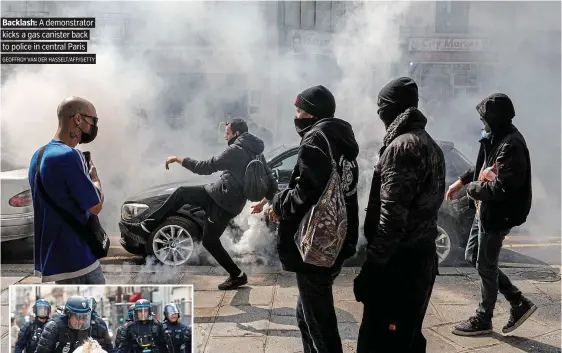  ?? GEOFFROY VAN DER HASSELT/AFP/GETTY ?? Backlash: A demonstrat­or
kicks a gas canister back to police in central Paris
