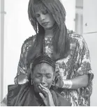  ?? HULU ?? Virgie ( Laverne Cox, standing) gives Anna ( Elle Lorraine) a weave that has a mind of its own in “Bad Hair.”