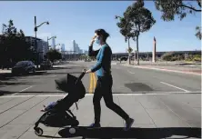  ?? Yalonda M. James / The Chronicle ?? Dr. Allison Bond, an infectious disease specialist at UCSF, crosses Mission Bay Boulevard with her 10monthold son.