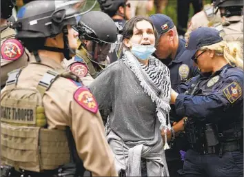  ?? Jay Janner Associated Press ?? AN ARREST is made Wednesday during a protest at the University of Texas at Austin. Students and a growing number of faculty are demanding amnesty for those facing disciplina­ry or legal action over protesting.