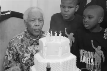  ??  ?? In this file photo, Nelson Mandela blows out candles as he celebrates his birthday in Johannesbu­rg.