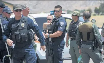  ?? Gina Ferazzi
Los Angeles Times ?? RIDGECREST POLICE officers join L.A. and Kern County sheriff’s deputies this week in the search for a killer. More than 75 deputies are combing caves, abandoned mines and twisting dirt roads in the remote area.