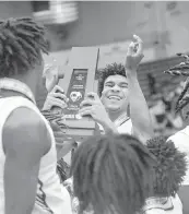  ?? SCOTT WHEELER | Photo ?? Norland’s Triston Wilson, the game-high scorer with 23 points, hoists the Class 5A state championsh­ip trophy after his team beat Tampa Blake to win the title Friday.