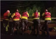  ?? MICHAEL YODAR — MEDIANEWS GROUP ?? Search and rescue crew members look at the flooding of the Manatawny Creek July 11 from a bridge in an attempt to try and locate a car that was swept away in in the flood in Douglass (Berks).