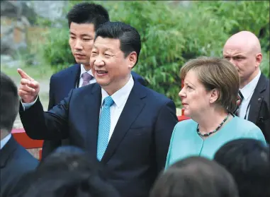  ?? JOHN MACDOUGALL / AFP ?? President Xi Jinping and German Chancellor Angela Merkel arrive for an official welcoming ceremony for a pair of pandas, one male and one female, at the Berlin Zoo on Wednesday.