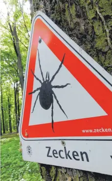  ?? FOTO: DPA ?? Zeckenwarn­ung in einem Waldgebiet: Die Zahl der FSME- Erkrankung­en war im vergangene­n Jahr in Baden-Württember­g und Bayern so hoch wie nie zuvor.