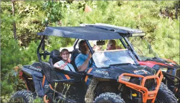  ?? PHOTO COURTESY OF ROBIN RICHARDS ?? Stacia and Zach Harmon, left, ride alongside Johnny Sowell and his son, Kyler, on the trails in Fairfield Bay. The roads, which are often used by locals for all-terrain vehicles, are in the process of being marked as trails to increase public safety.