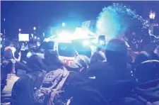  ?? JIM MICHAUD / BOSTON HERALD ?? TAKING TO THE STREETS: Protesters clash with police as a liquid flies through the air. The National Guard was called in for crowd control when protests that were peaceful earlier in the day turned violent.