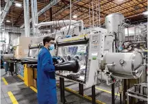  ?? Associated Press file photo ?? Test engineer Jacob Wilcox pulls his arm out of a glove box used for processing sodium at TerraPower, a company that’s developing and building small nuclear reactors.