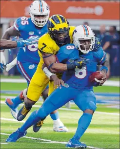  ?? TONY GUTIERREZ/AP PHOTO ?? Florida quarterbac­k Malik Zaire (8) is sacked by Michigan safety Khaleke Hudson during the second half of the No. 11 Wolverines’ 33-17 win over the No. 17 Gators on Saturday in Arlington, Texas.