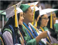  ??  ?? Miranda Grasmick and Terrell Calabaza listen to a speech from salutatori­an Dominic Roybal.