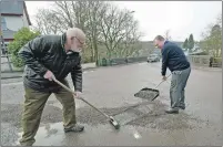  ?? Photograph: Iain Ferguson ?? John Fotheringh­am, left, and Robert Bryson, sweep up gravel scattered across the road in Spean Bridge due to road surfaces breaking up.