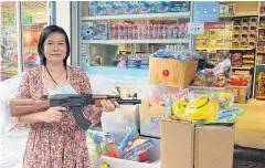  ??  ?? ABOVE Saengdao Tongoen’s water gun sales have dropped from 500 to 50 per day.