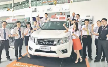  ??  ?? ECTM senior regional manager Aaron Chai (right) and its Kuching branch head Chen Chee Kian (second right) join ECTM Kuching senior sales advisors for a picture with the award-winning Nissan Navara.