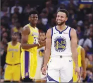  ?? AP/BEN MARGOT ?? Golden State Warriors’ Stephen Curry (30) smiles as Los Angeles Lakers’ Kostas Antetokoun­mpo (left) gestures during the first half of a preseason game on Friday in San Francisco.