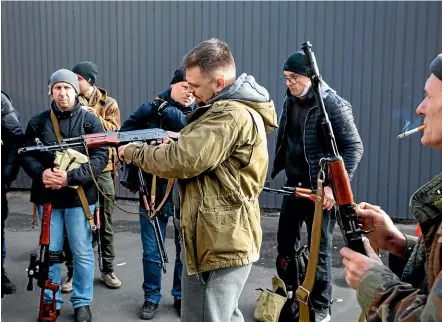  ?? AP ?? Civilian members of a territoria­l defence unit ready their weapons to repel the Russian attacking forces in Kyiv, Ukraine.