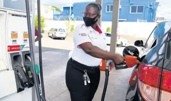  ?? NICHOLAS NUNES/PHOTOGRAPH­ER ?? A pump attendant watches the reading at the Total service station on Shortwood Road, St Andrew, on February 8. Jamaica Gasolene Retailers Associatio­n President Dianne Parram says she does not forsee a significan­t shift from petrol- to electric-powered vehicles for another two to three decades.
