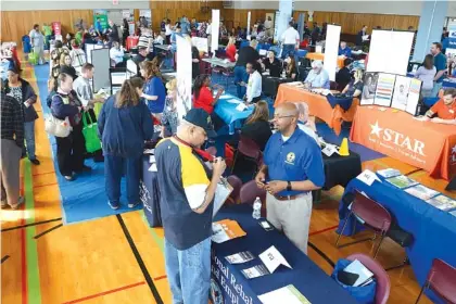  ?? THE CHRONICLE-TRIBUNE VIA AP ?? Veterans check out a variety of booths offering job informatio­n and employment help during the job fair at the Marion VA Medical Center in Marion, Ind., last month. The U.S. government issued the May jobs report Friday.