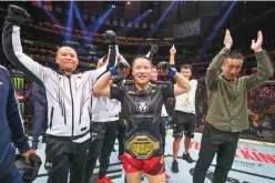  ?? Photo: VCG ?? Zhang Weili (center) of China reacts after defeating Carla Esparza of the US in the UFC strawweigh­t championsh­ip bout during the UFC 281 event at Madison Square Garden in New York City on November 12, 2022.