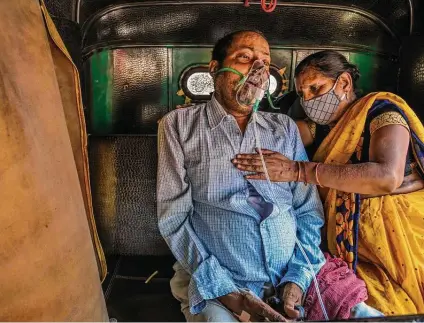  ?? Atul Loke / New York Times ?? A relative in Delhi helps a man sitting in a motorized rickshaw receive oxygen for his COVID-19 symptoms. A vaccine developed at a Texas Children’s lab could provide relief for future waves in India, where less than 10 percent of the population is fully vaccinated.