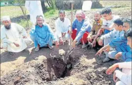  ?? PTI ?? Villagers point to a hole caused by a mortal shell after the Pakistan Army pounded forward posts and civilian areas along the LoC in Mankot area in Mendhar sector of Poonch on Monday.