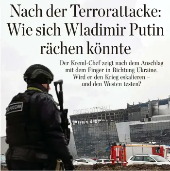  ?? STRINGER / AFP ?? Ein Mitglied der russischen Sicherheit­skräfte steht vor der Crocus City Hall in Krasnogors­k, auf die am Freitagabe­nd ein Anschlag verübt wurde, bei dem mindestens 137 Menschen starben.