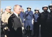  ?? MIKHAIL KLIMENTYEV, SPUTNIK, KREMLIN POOL PHOTO VIA AP ?? Russian President Vladimir Putin, second from left, and Defense Minister Sergei Shoigu, left, chat with Russian military pilots at Hemeimeem air base in Syria on Monday.