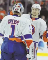  ?? AP PHOTO ?? GOLDEN ROAD: Islanders goalie Thomas Greiss is joined by Adam Pelech as they celebrate their overtime victory against Philadelph­ia yesterday.