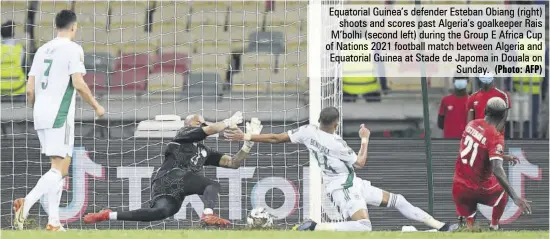  ?? (Photo: AFP) ?? Equatorial Guinea’s defender Esteban Obiang (right) shoots and scores past Algeria’s goalkeeper Rais M’bolhi (second left) during the Group E Africa Cup of Nations 2021 football match between Algeria and Equatorial Guinea at Stade de Japoma in Douala on Sunday.