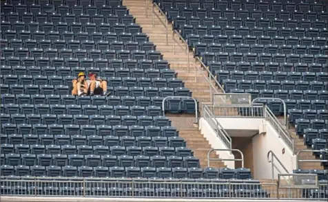  ?? Ben Braun/Post-Gazette ?? Two fans sit alone in a sea of empty seats at PNC Park while the Pirates play the Milwaukee Brewers on July 28. The Pirates have a large influence on bringing business and revenue to Pittsburgh, but when they go on a losing streak, that influence can turn and negatively affect businesses’ bottom lines.