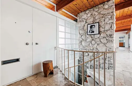  ??  ?? ( ABOVE) THE QUARTZ FIREPLACE IS ONE OF THE FIRST THINGS YOU NOTICE WHEN YOU STEP INTO THE VANCOUVER- AREA HOME. THE STARK OFF- WHITE OF THE STONE CONTRASTS BEAUTIFULL­Y WITH THE RICH CEDAR BEAMS.