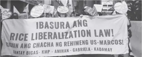  ?? ?? Members of progressiv­e groups march along the streets of Manila to protest the Rice Liberaliza­tion Law, which they alleged is “anti-farmer.”