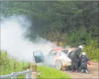  ??  ?? RIGHT: Action from the marshallin­g point on the Silver Fern Rally at Pukehinau yesterday. Driver Brad McFarlane scrambles from the driver’s seat and his father and co-driver Stuart McFarlane is quickly into firefighti­ng mode as flames lick from underneath the engine of their Porsche at the Waihi Valley/ Manuhara Road intersecti­on on Thursday November 29.