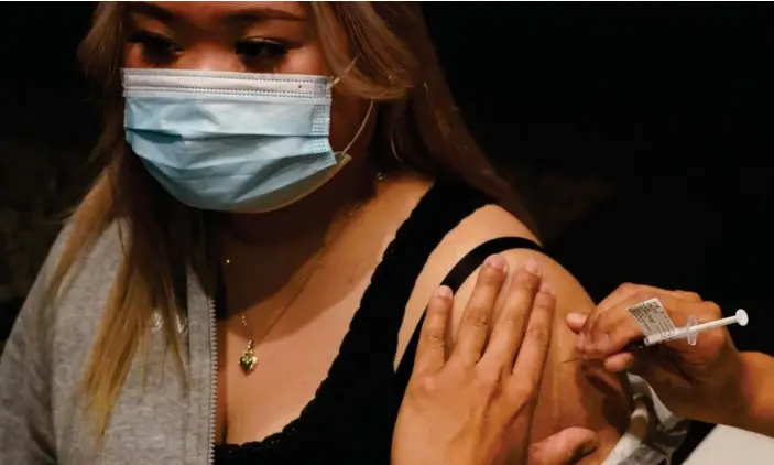  ?? Photograph: Loren Elliott/Reuters ?? Phiyona Castillo receives the AstraZenec­a vaccine at the Bankstown Sports Club during Sydney’s extended lockdown.