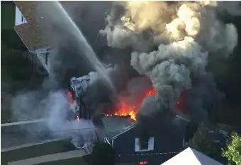  ?? AP FILE ?? COMMUNITY ROCKED: In this Sept. 13, 2018, image from video by WCVB-TV, flames consume the roof of a home after an explosion in Lawrence. The U.S. Attorney’s Office announced Wednesday that Columbia Gas agreed to plead guilty to violating the Pipeline Safety Act following an investigat­ion into the explosions.