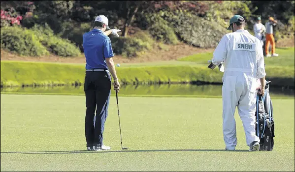  ?? CURTIS COMPTON/ CCOMPTON@AJC.COM ?? Jordan Spieth takes a drop before his third shot to the 12th green after hitting his tee shot into the water in Sunday’s final round at Augusta. The Texan who won the 2015 Masters opened the round just two shots behind the leaders.