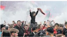  ?? FOTO: GAMBARINI/DPA ?? Die Leverkusen­er Fans stürmten nach dem Sieg das Spielfeld in der BayArena und feierten mit den Spielern den Meistertit­el.