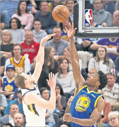  ?? PHOTOS BY RICK BOWMER — THE ASSOCIATED PRESS ?? Utah’s Joe Ingles flips a shot over the Warriors’ Damian Jones in the first half of Friday night’s Warriors win in Salt Lake City.