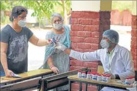  ?? PARVEEN KUMAR/HT ?? ■
A health worker hands over medicines to a woman during a swab collection drive in Gurugram on Sunday.