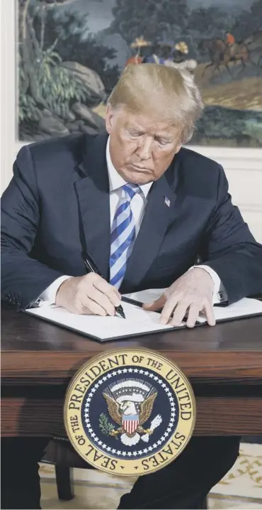  ??  ?? 0 Donald Trump signs a presidenti­al memorandum on the Iran nuclear deal yesterday