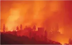  ?? — AFP ?? Flames from the Camp fire burn near a home atop a ridge near Big Bend, California.
