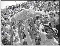  ?? AP/BEN CURTIS ?? Supporters of Emmerson Mnangagwa, Zimbabwe’s president in waiting, pass around a stuffed crocodile Wednesday as they await his arrival in Harare. Mnangagwa is a former justice and defense minister who served as ousted President Robert Mugabe’s...
