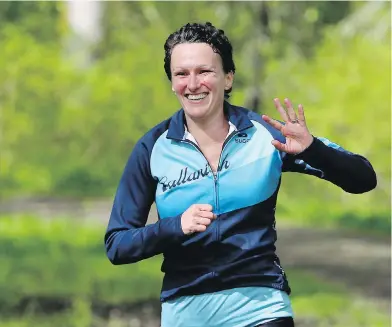  ??  ?? A joyful Lise Berube runs along the Elk/Beaver Lake trail on Friday.