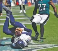  ?? AP PHOTO/JAMES KENNEY ?? Tennessee Titans quarterbac­k Marcus Mariota dives into the end zone to score a touchdown against the Philadelph­ia Eagles in the second half Sunday.