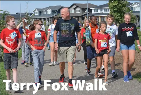  ?? SCOTT ANDERSON/SOUTHWEST BOOSTER ?? Fred Fox, the older brother of Terry Fox, walks with a group of Ecole Centennial students on Monday during their Terry Fox School Walk.