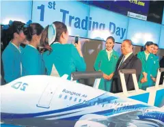  ??  ?? Mr Puttipong and staff on the airline’s first trading day, Nov 3, 2014.